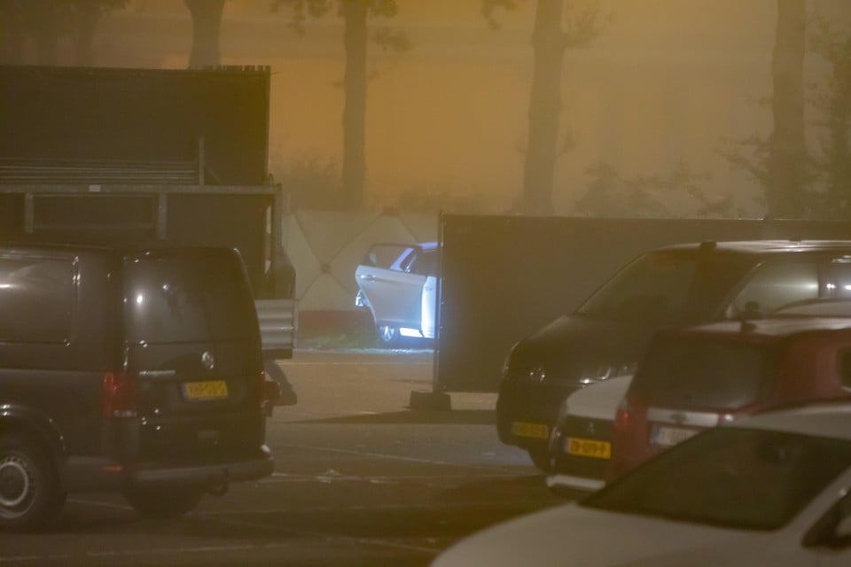 De witte Volkskwagen waarin donderdagavond een dode persoon werd aangetroffen, wordt onderzocht en afgeschermd door de politie.