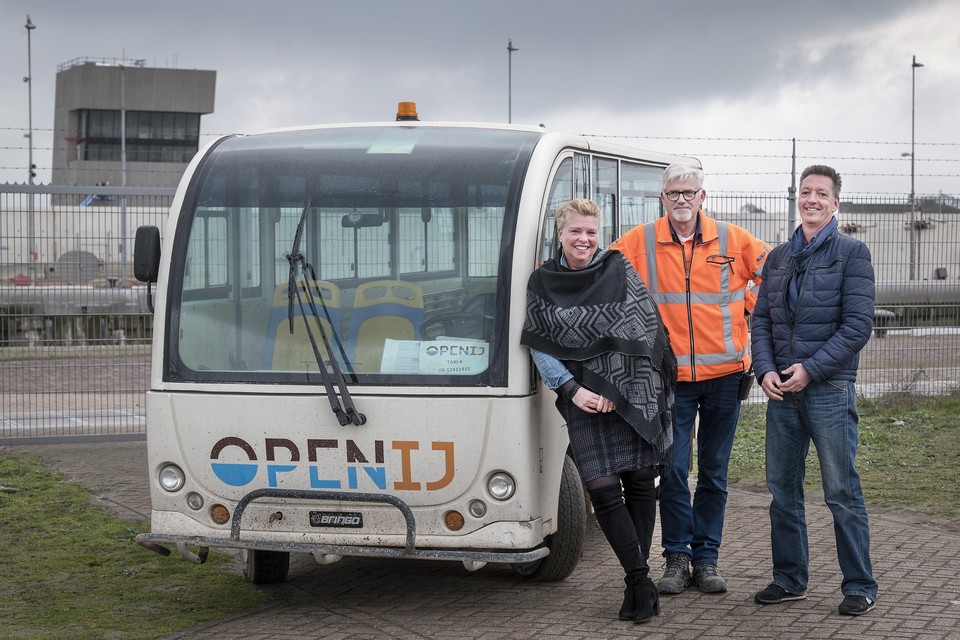 Jan Fortuin (midden) die eerst werkloos was maar aan de slag kon als taxichauffeur op het bouwterrein. Naast hem staan Jennifer Smits van OpenIJ en Jan Rienstra van Rijkswaterstaat.