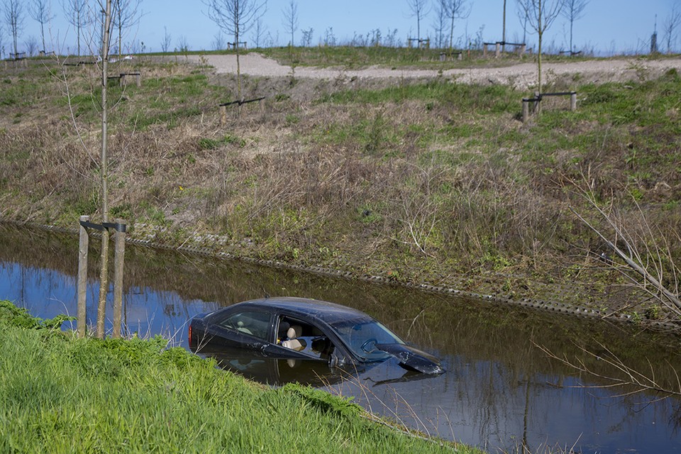 Auto te water langs N205 in Haarlem. Foto Michel van Bergen