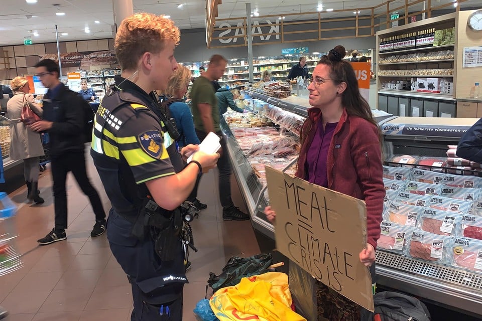Laura ten Brink in gesprek met een politieagent. De Haarlemse is sinds een jaar actief bij Extinction Rebellion. ,,Als ik ga demonstreren passen mijn ouders op mijn hondjes.’’
