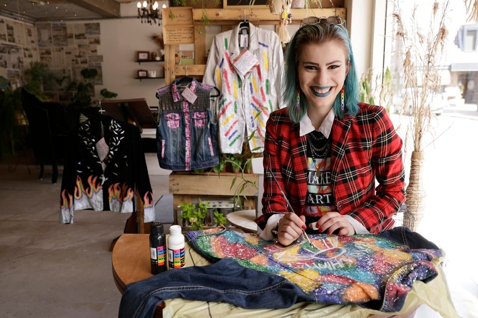 Restyle designer Lisa Brouwer is net zo kleurrijk als haar werk. Aan de kast van links naar rechts een jasje uit de rainbowcollectie, haar eerste restyle spijkerjasje en een colbertje uit de artcollectie.