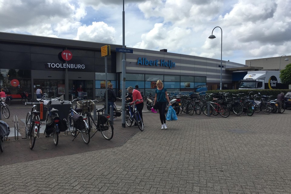 Netjes en ’wild’ gestalde fietsen met op de achtergrond het zebrapad naar het winkelcentrum. Rechts de laad- en losplaats van de Albert Heijn.