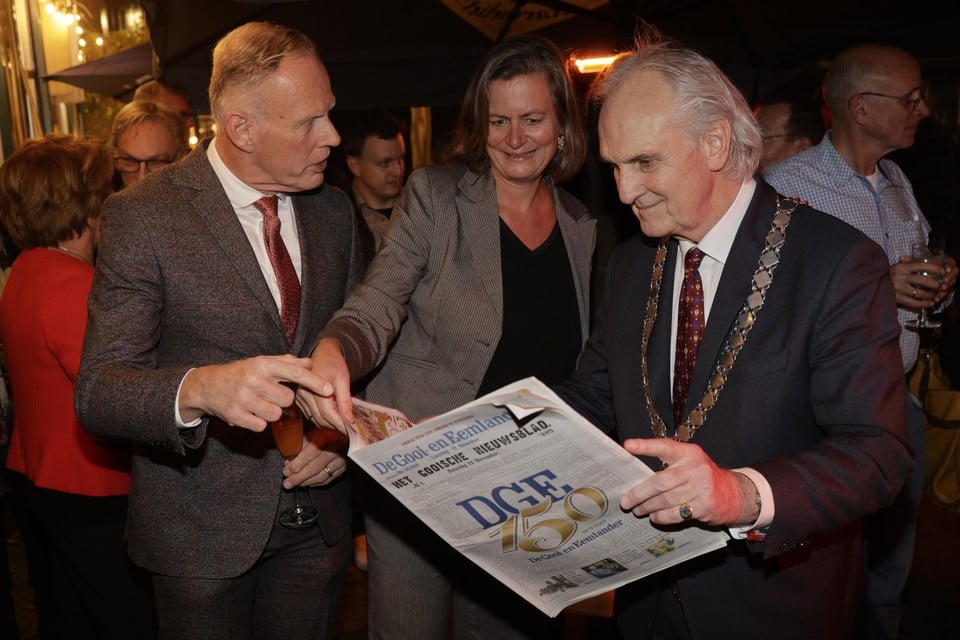 Burgemeester Broertjes neemt de jubileumkrant van De Gooi- en Eemlander in ontvangst van hoofdredacteur Corine de Vries. Links burgemeester Han ter Heegde van Gooise Meren.