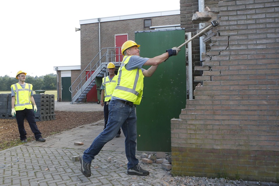 Secretaris Koos Bakker haalt muurtje neer ten behoeve van nieuwbouw clubhuis HSV De Zuidvogels.