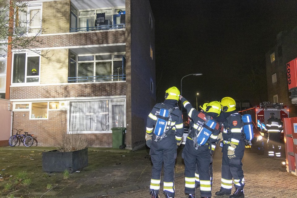 Brandweerlieden bij de woningbrand in de Professor Krausstraat in Schalkwijk.