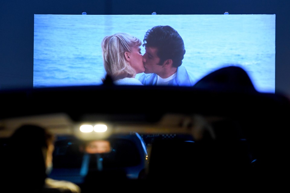 Cinema-goers in their cars attend the screening of the US musical romantic comedy film "Grease" during the reopening of the Autocine Madrid Race drive-in cinema, on May 27, 2020 in Madrid, as Spain eases lockdown measures taken to curb the spread of the COVID-19 disease caused by the novel coronavirus. For many, it was a long-awaited chance to feel normal again, sitting in their cars belting out "Summer Nights" at Madrid's drive-in cinema on a rare night out after a 10-week lockdown. Gabriel BOUYS / AFP
