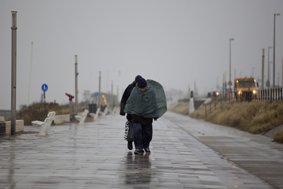 Wandelaars trotseren de storm in Zandvoort. Foto Michel van Bergen