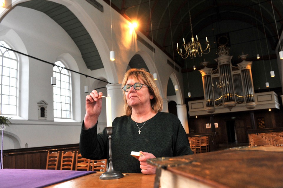 Lukie Dijkstra steekt kaarsen aan in de protestantse kerk in Uitgeest.
