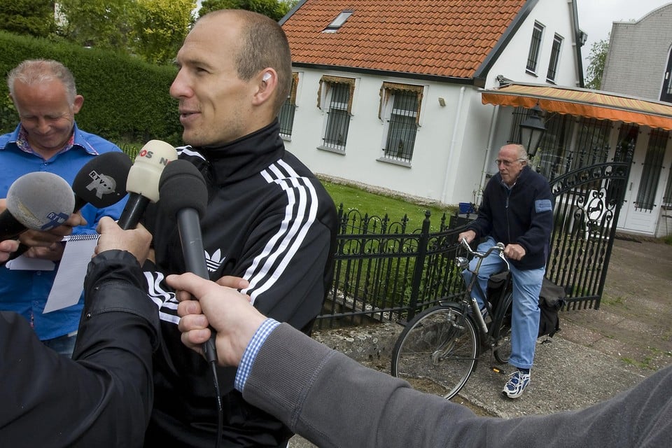 Arjen Robben staat bij het huis Van Toorn de pers te woord terwijl de fysiotherapeut op zijn fiets de journalisten ontwijkt.