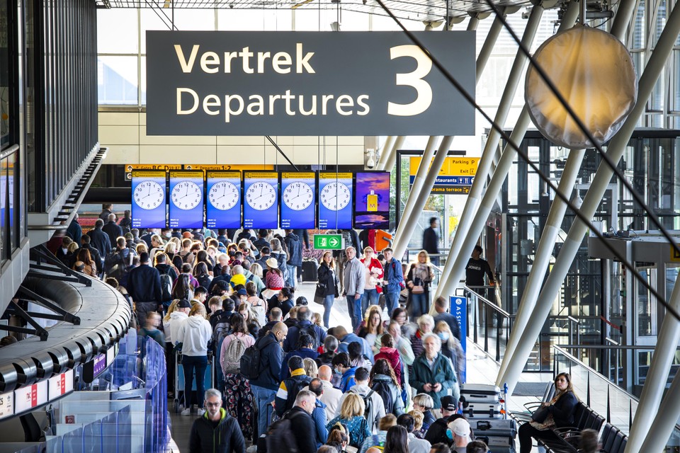Reizigers in een vertrekhal op Schiphol afgelopen zondag. Na de staking door personeel van KLM een dag eerder waardoor veel vluchten uitvielen, waarschuwt Schiphol dat het extra druk kan zijn op de luchthaven.