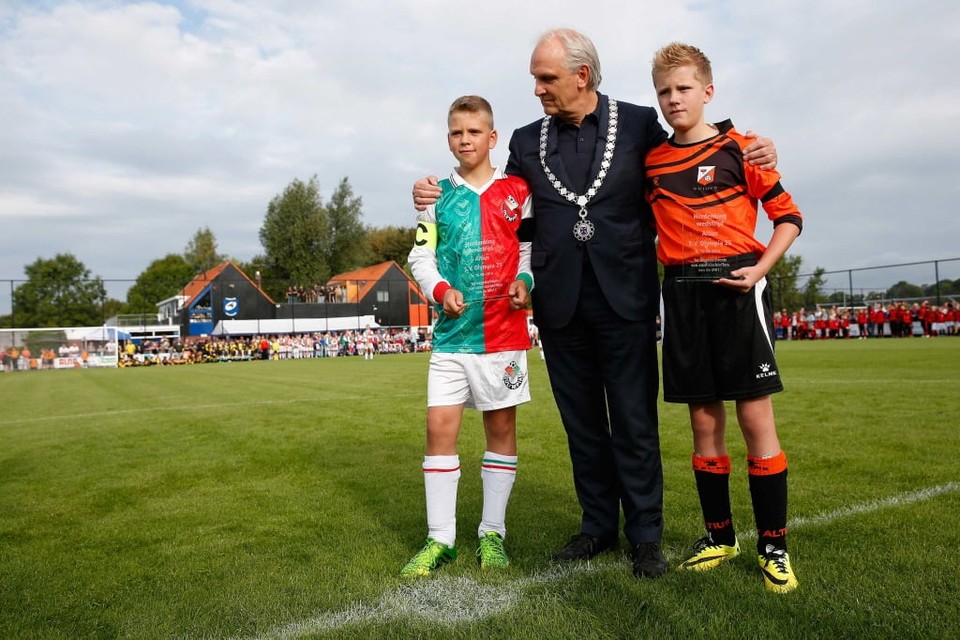 Burgemeester Pieter Broertjes van Hilversum poseert met de aanvoerders van de teams van Altius en Olympia voor aanvang van een herdenkingswedstrijd op sportpark Beerenstein. Foto ANP