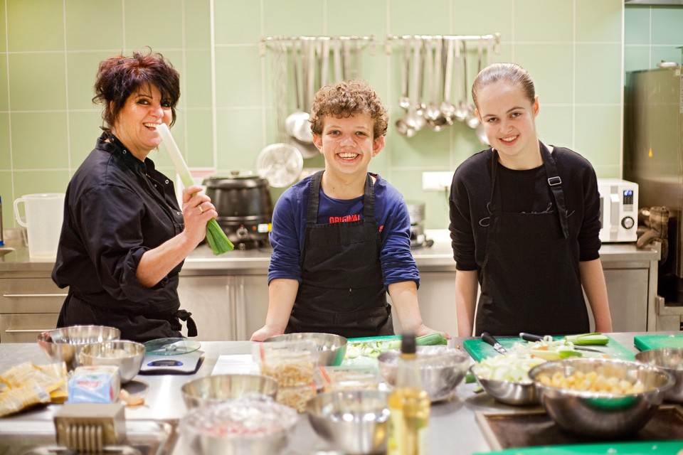 Bianca van Laar (l) met Ties (m) en Nikki (r) in de keuken van Heliomare